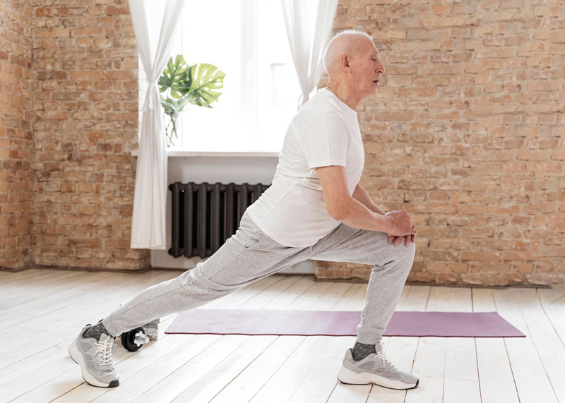 Hombre mayor haciendo ejercicios de estiramiento en interior