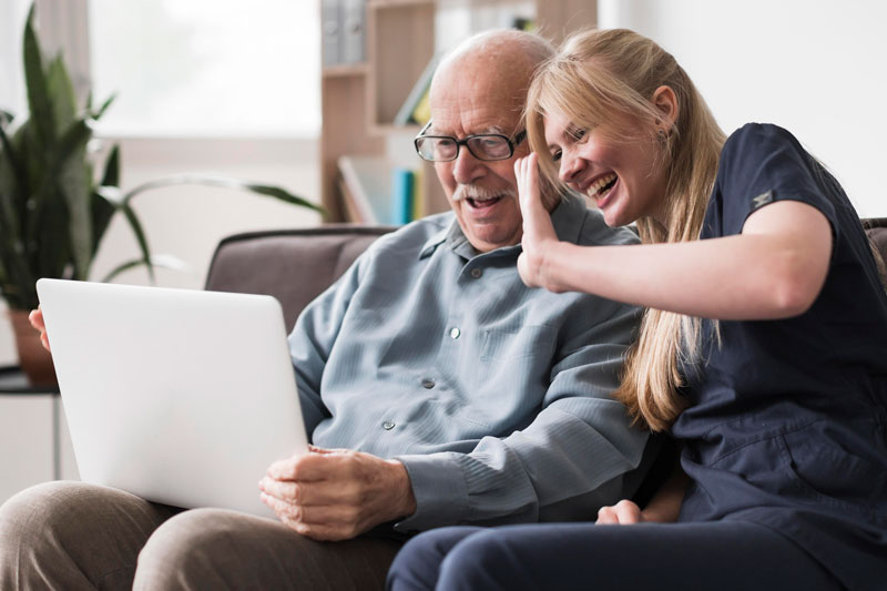 Persona mayor en residencia hablando con su familia en línea