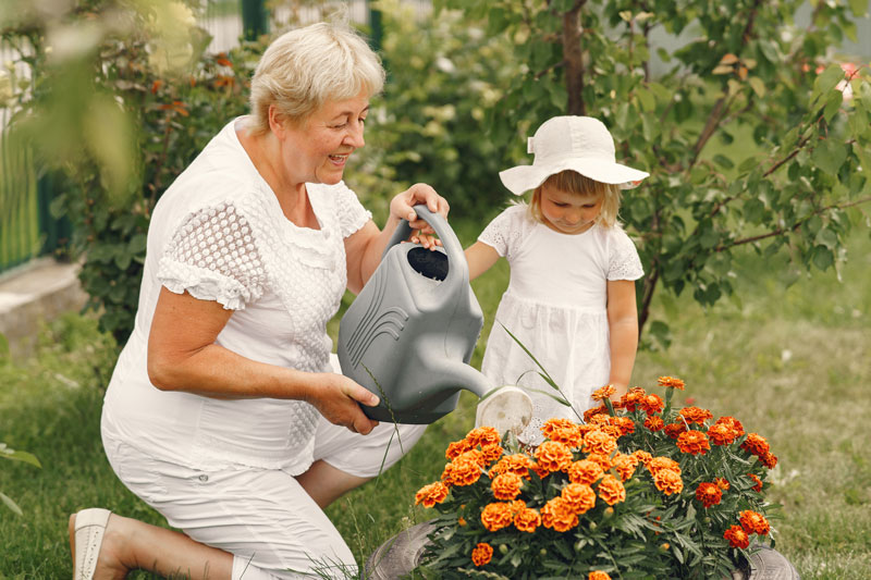 Abuela y nieta, cuidando el jardín